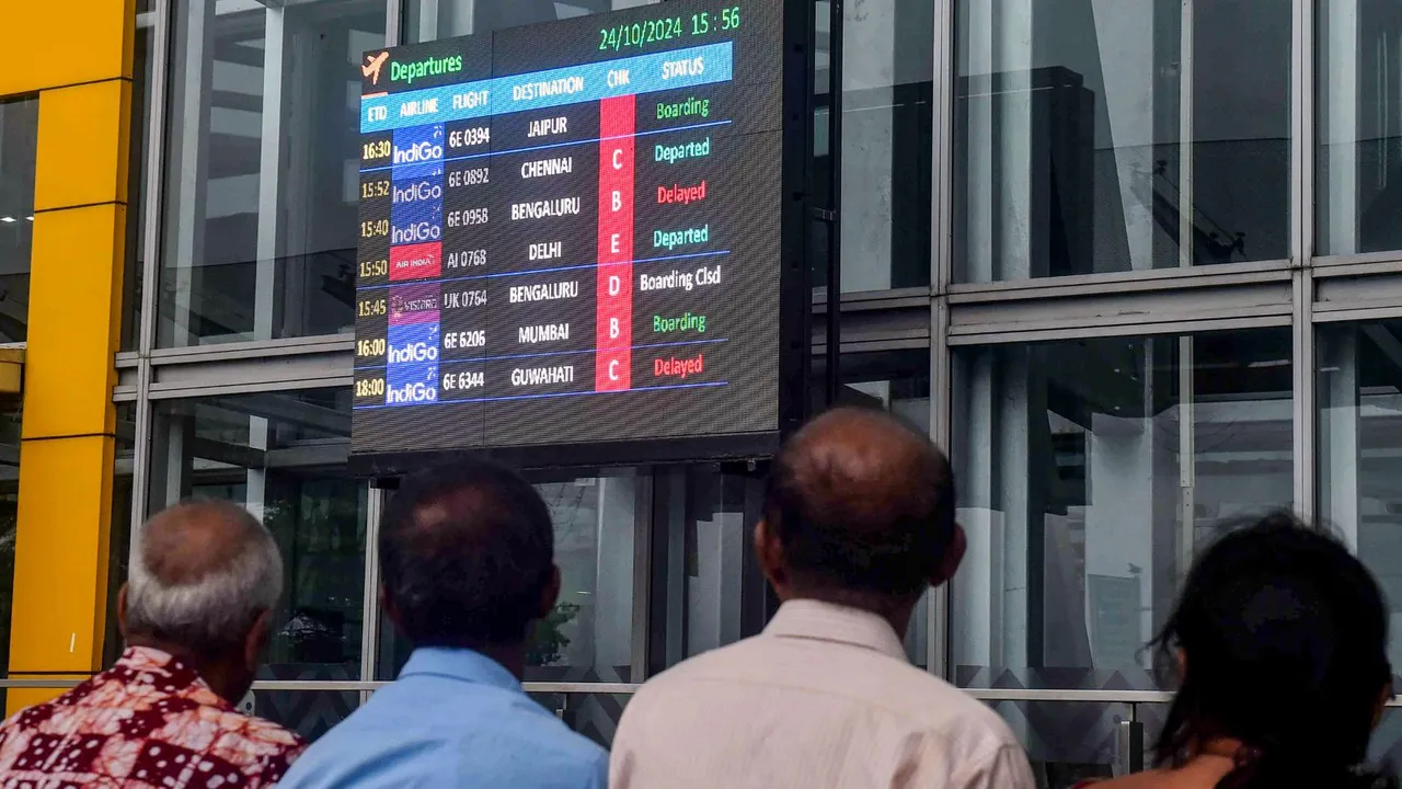 Passengers look at the display board for information after several flights were cancelled in view of cyclone 'Dana' which is expected to make landfall in Odisha, at Netaji Subhas Chandra Bose International Airport, in Kolkata, Thursday, Oct 24, 2024.