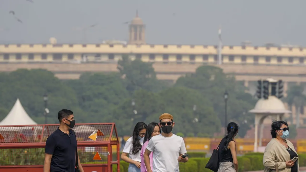 Foriegn tourists wearing face masks as air quality continues to remain poor, at Vijay Chowk, in New Delhi, Wednesday, Oct. 23, 2024