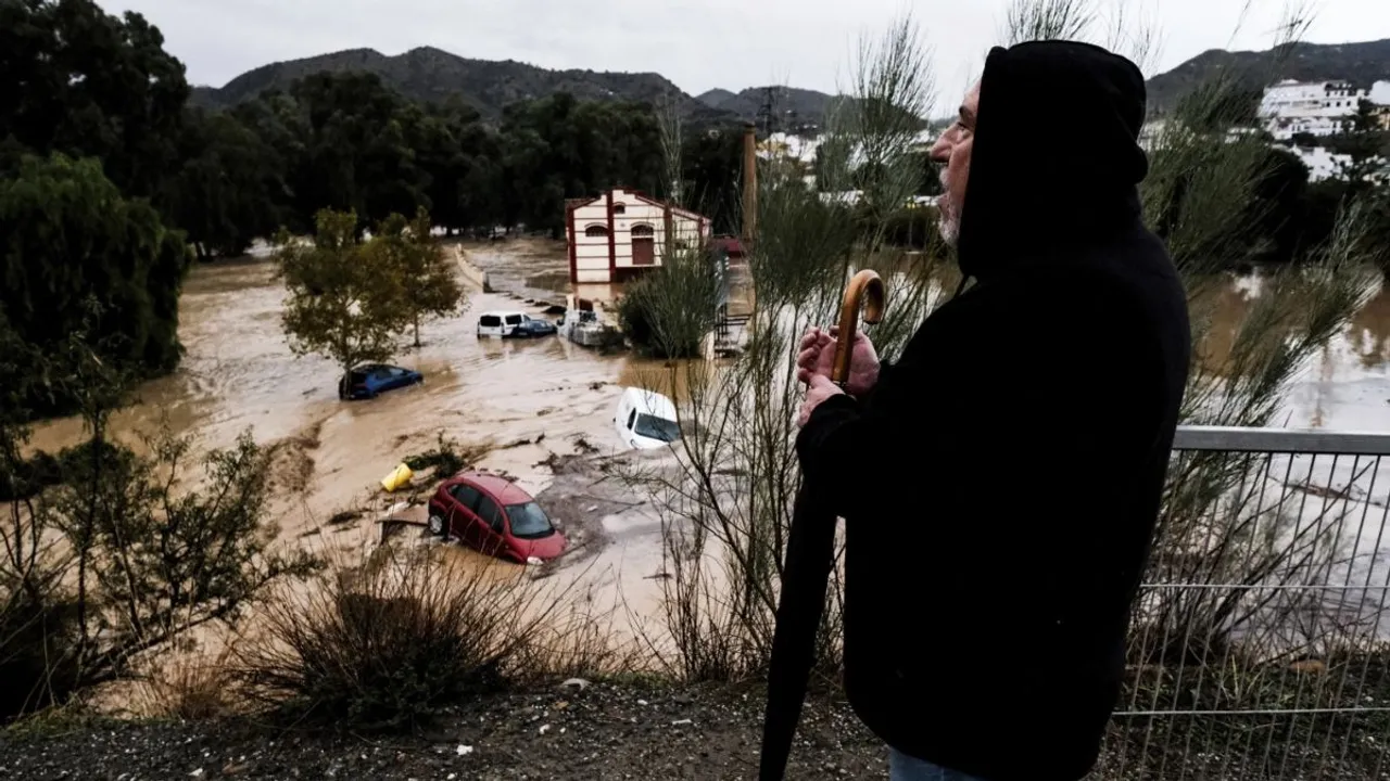 A man observes several cars being swept away by the water, after floods preceded by heavy rains caused the river to overflow its banks in the town of Alora, Malaga, Spain, Tuesday, Oct. 29, 2024