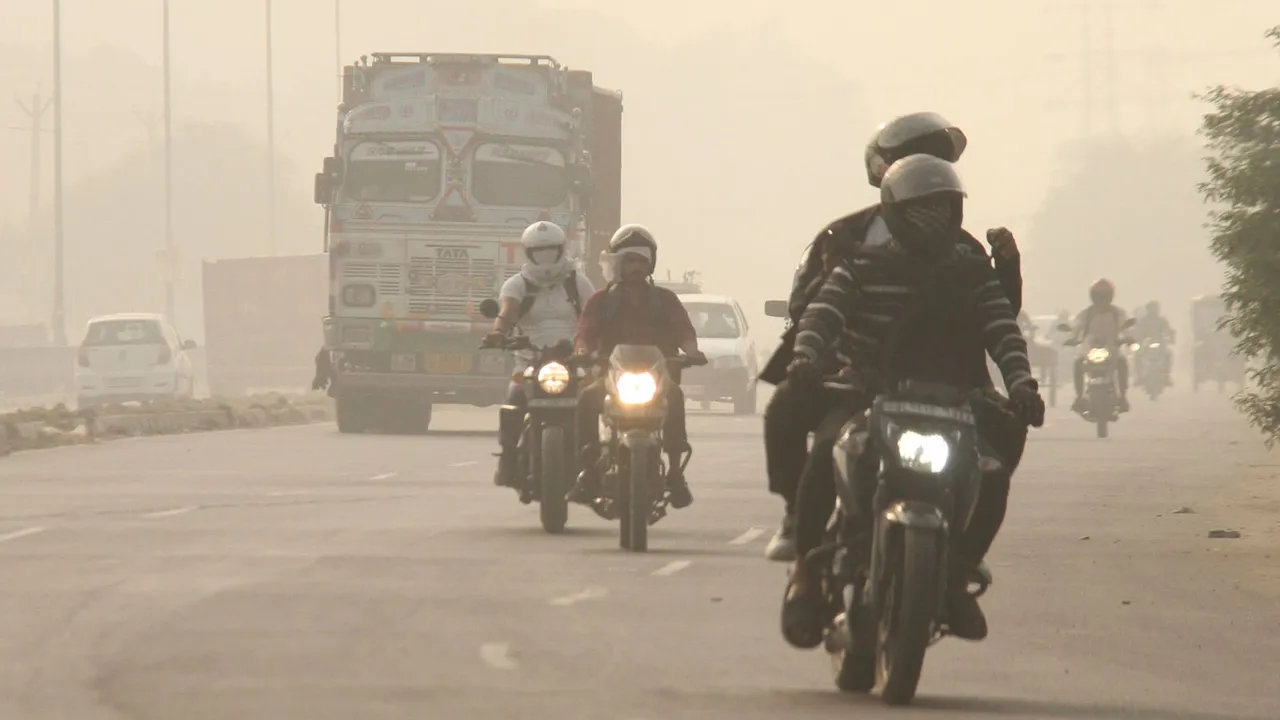 Vehicles ply on a road amid low visibility due to smog, in Gurugram, Haryana