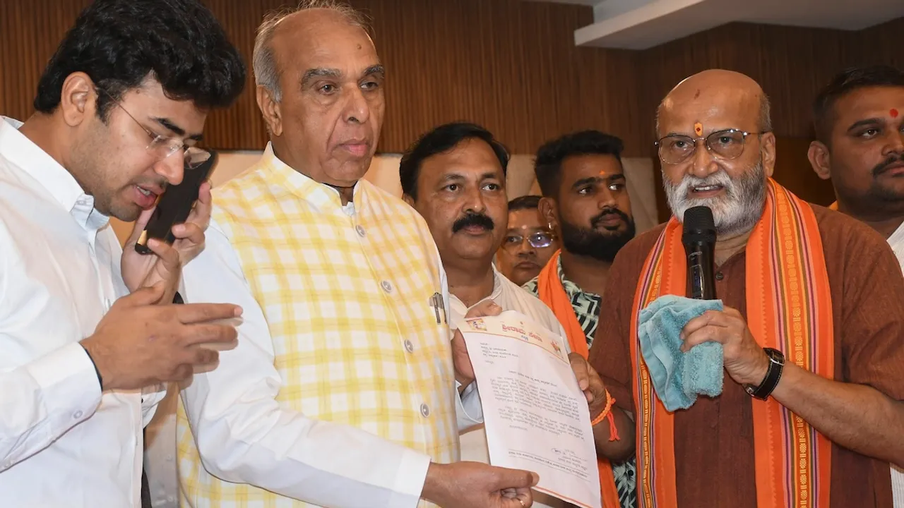 Joint Committee of Parliament on the Waqf (Amendment) Bill Chairman Jagdambika Pal shows a petition that he received after a meeting with local farmers regarding their lands being claimed by the State Waqf Board, in Hubballi, Karnataka, Thursday, Nov. 7, 2024. BJP MP Tejasvi Surya and Sri Ram Sena chief Pramod Muthalik are also seen.