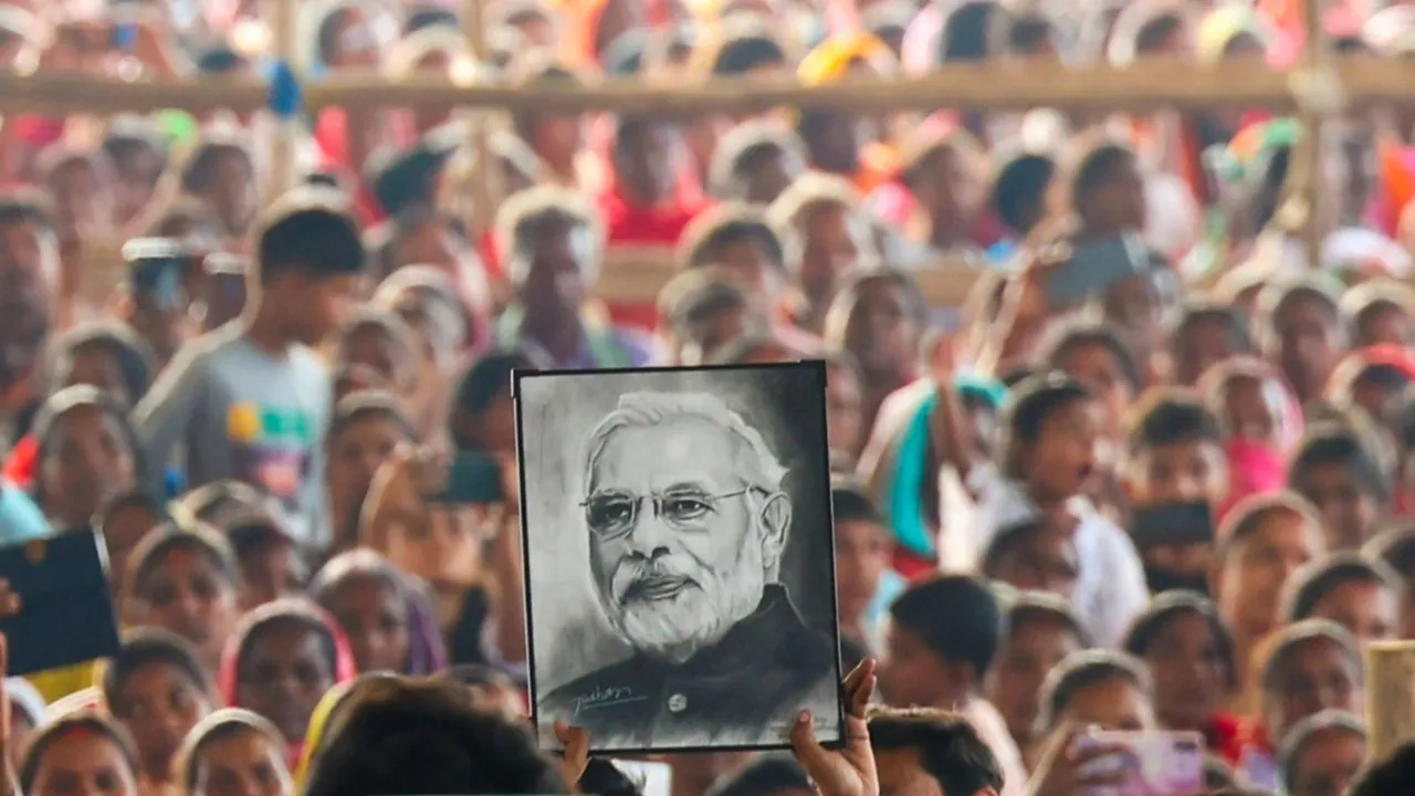A supporter holds portrait of Prime Minister Narendra Modi during a public meeting, in Gumla district, Jharkhand