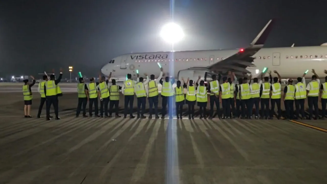 Employees wave at a Vistara plane on the last day of the airline's operation before its integration with Air India, in Ahmedabad, Monday, Nov 11, 2024.