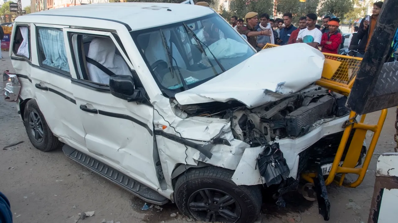 People stand near a damaged vehicle after a taxi collided with Rajasthan CM Bhajan Lal Sharma's convoy at Akshay Patra crossing in Jaipur on Wednesday, Dec. 11, 2024.