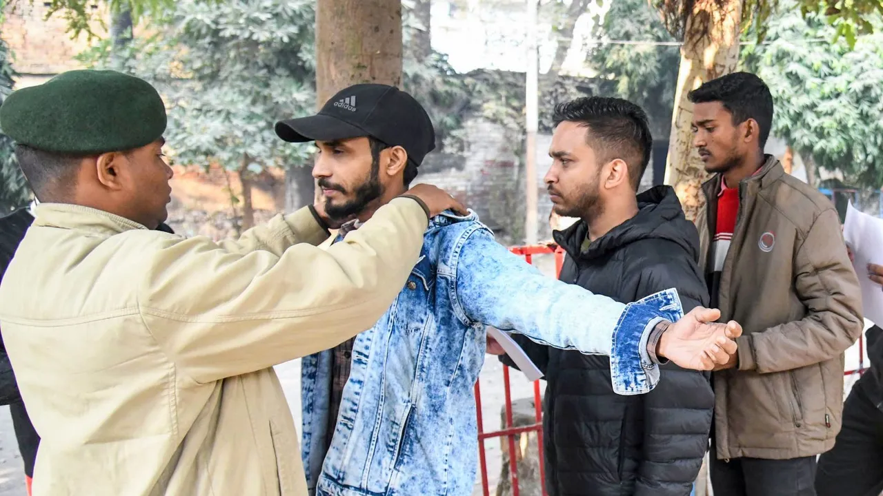 Applicants undergo security checks outside an exam center before appearing for the Bihar Public Service Commission's 70th Combined (Preliminary) Examination, in Patna, Friday, Dec. 13, 2024.