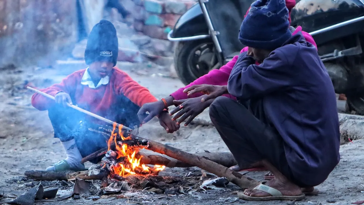 People sit around a bonfire to warm themselves during a cold winter morning in New Delhi on Saturday, Dec. 14, 2024.