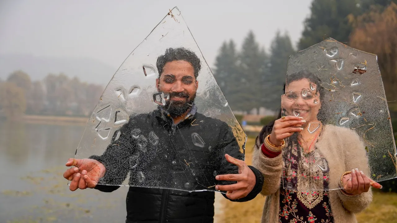 A tourist couple poses with ice pieces on a cold winter day, in Srinagar, Thursday, Dec. 19, 2024.