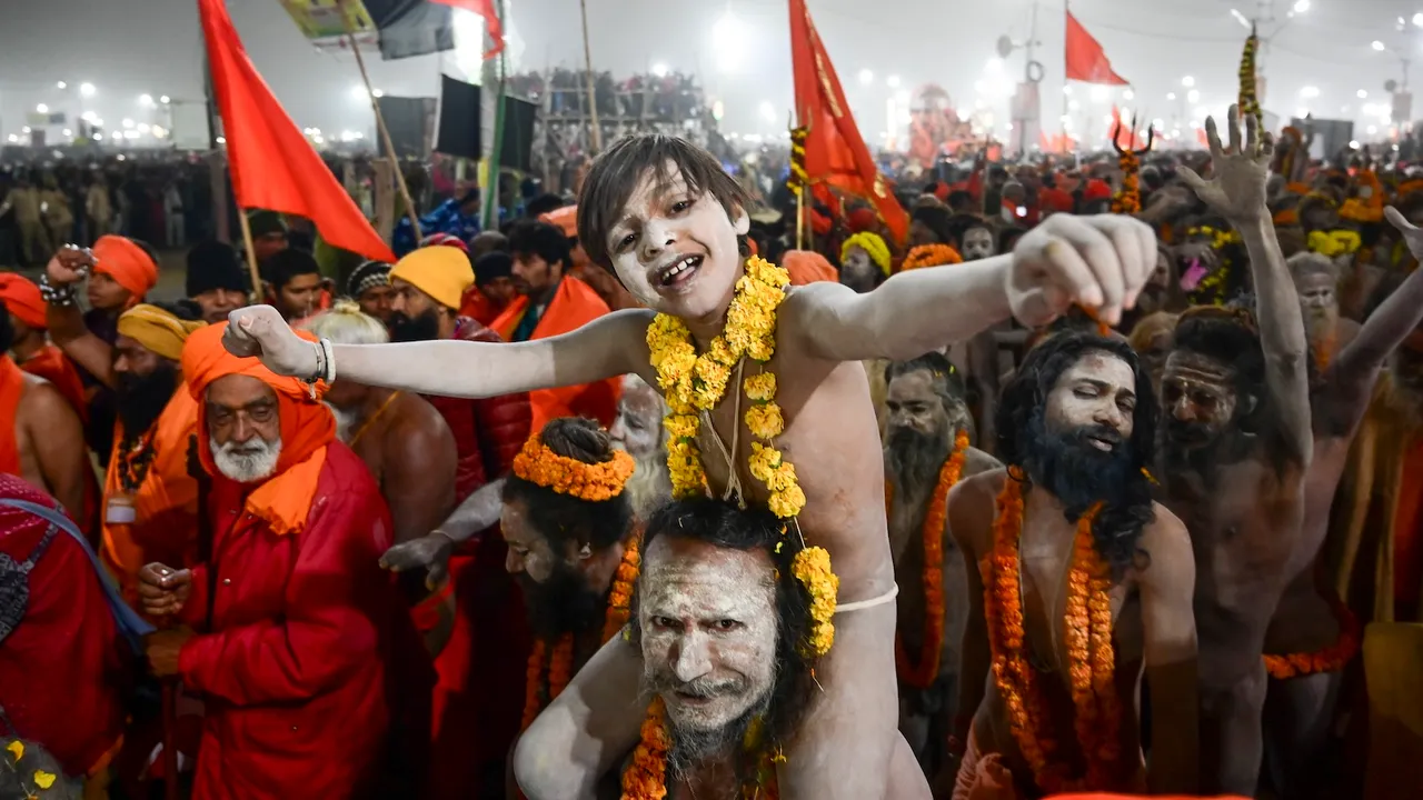 A 'Naga Sadhu' with a young devotee at Sangam on the occasion of 'Makar Sankranti' during the Maha Kumbh Mela 2025 in Prayagraj  on Tuesday, Jan. 14, 2025.