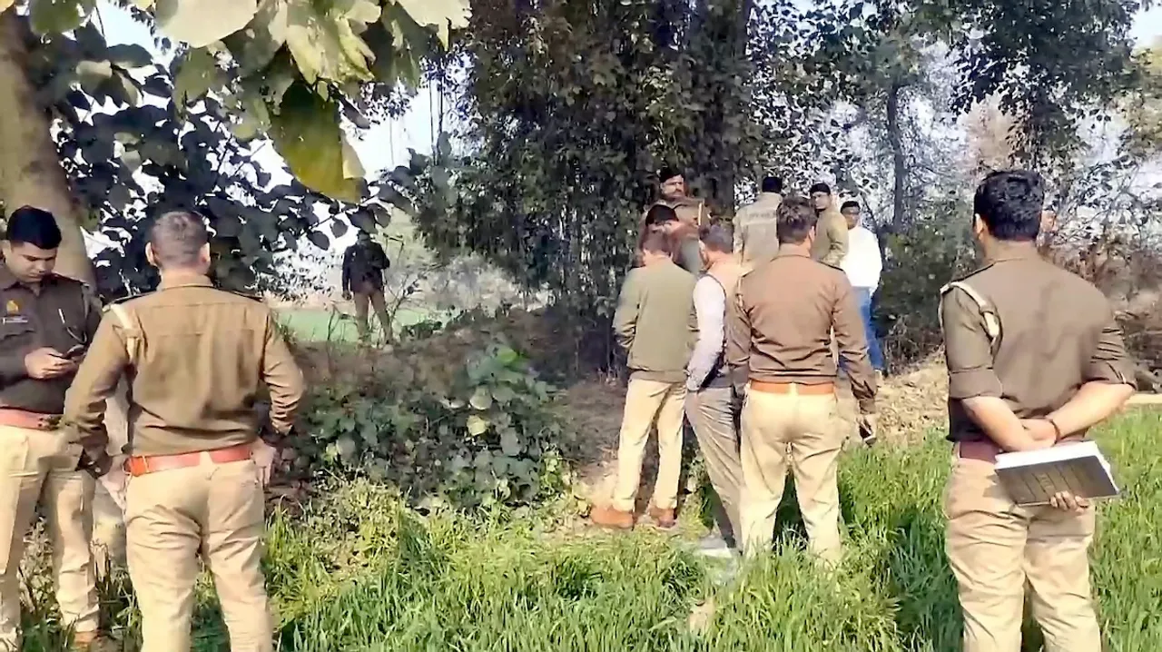 Police personnel inspect the site where an unclothed body of a 22-year-old Dalit woman, who was missing, was found on Saturday in a canal at a village in Ayodhya, Uttar Pradesh on Sunday, Feb. 2, 2025.