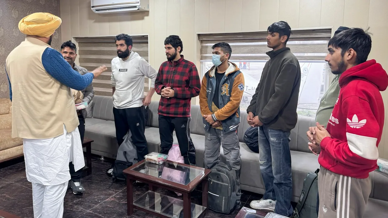 Punjab NRI Affairs Minister Kuldeep Singh Dhaliwal, front left, interacts with illegal Indian immigrants, who were deported from the US, upon their arrival, in Amritsar, Wednesday, Feb. 5, 2025.