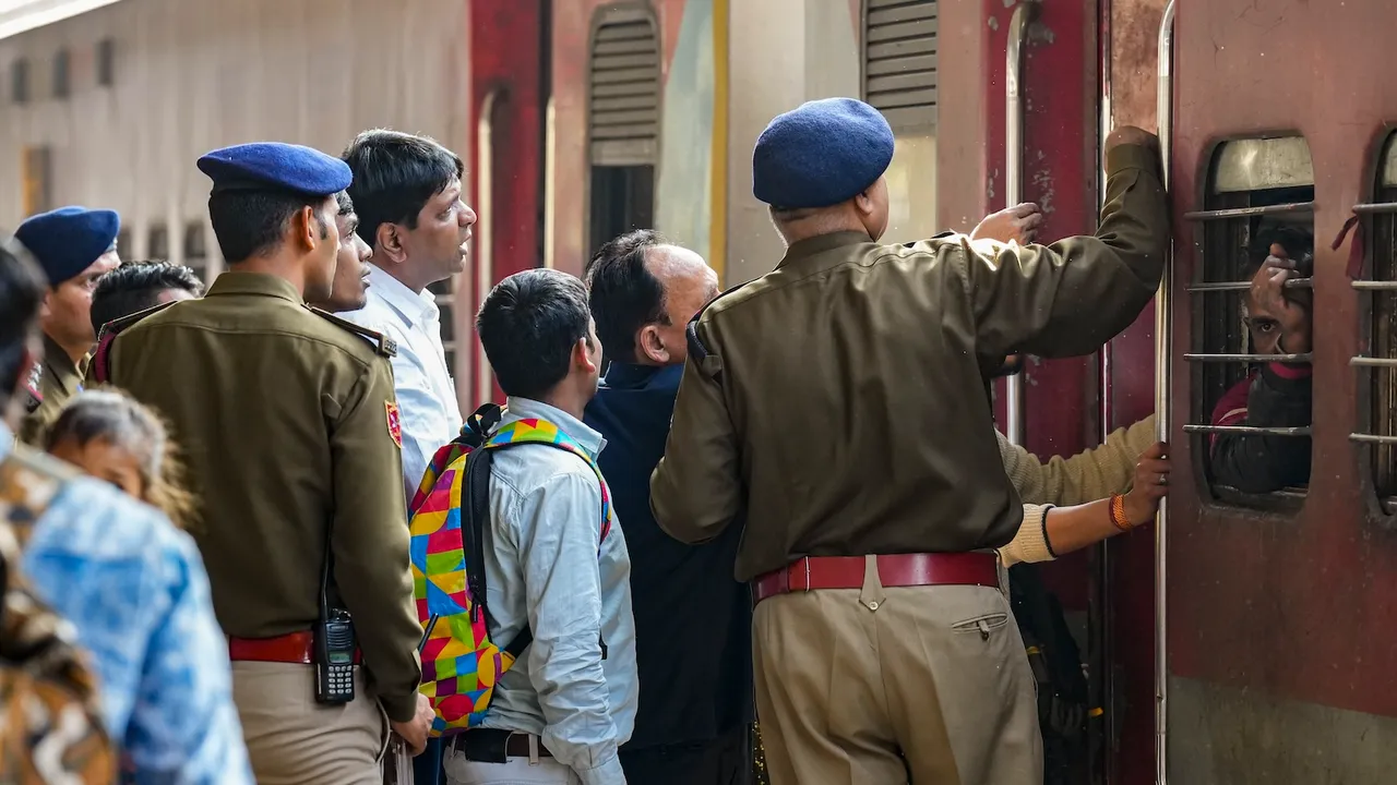 Security personnel manage passengers boarding a train at the New Delhi Railway Station in New Delhi on Monday, Feb. 17, 2025. 