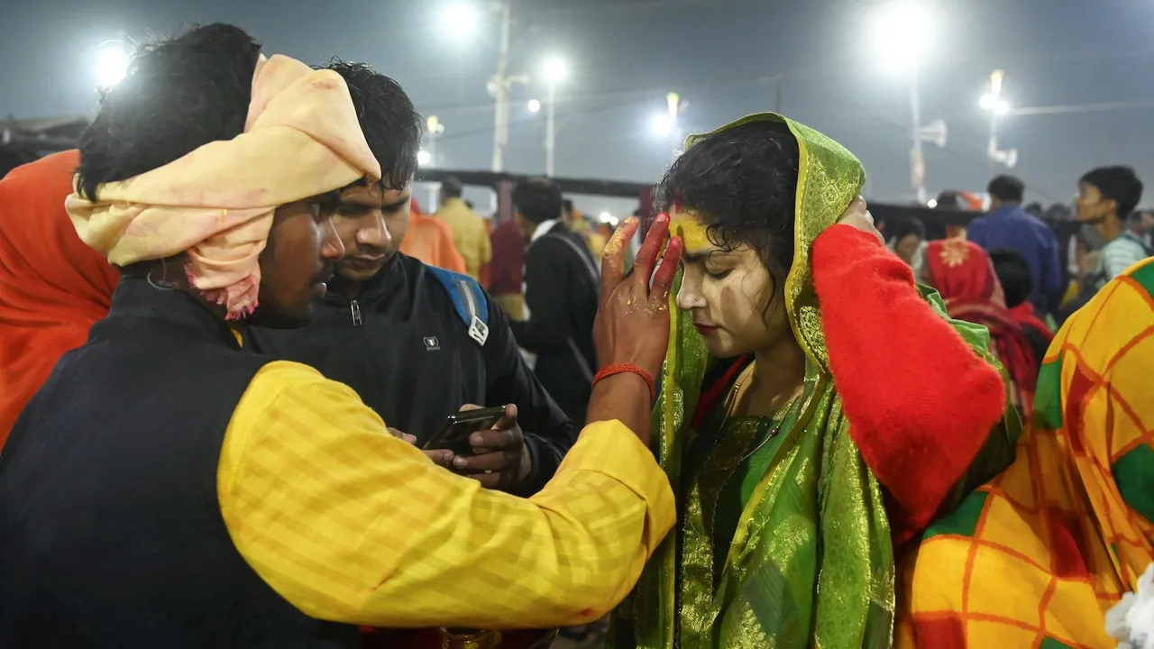 A woman devotee gets ‘tika’ on her forehead after taking a holy dip in the Ganga river on Maha Shivratri at Maha Kumbh in Prayagraj on Wednesday, Feb 26, 2025.