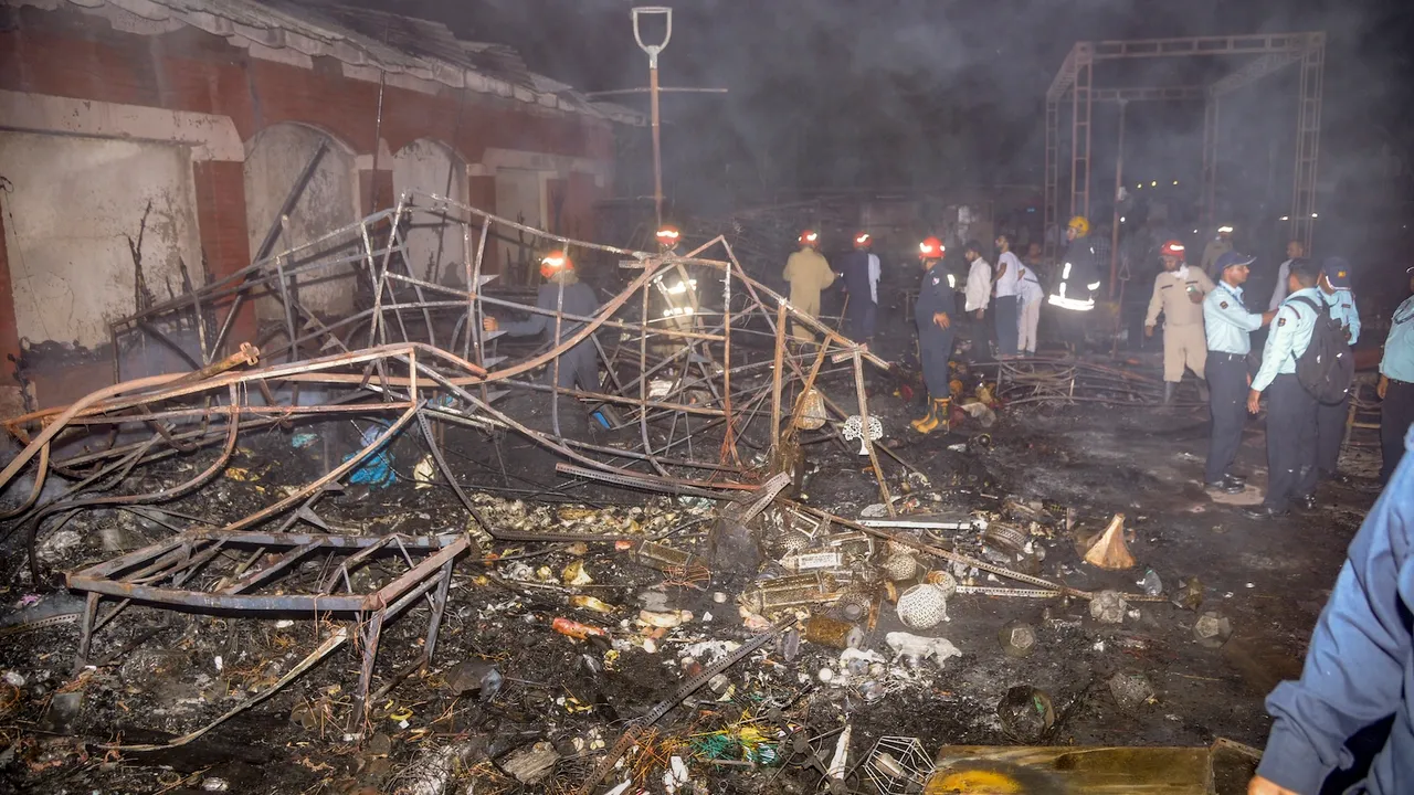 Firemen and other officials sift through charred remains after a fire broke out at the Dilli Haat, a popular market, at INA, in New Delhi, Wednesday, April 30, 2025.