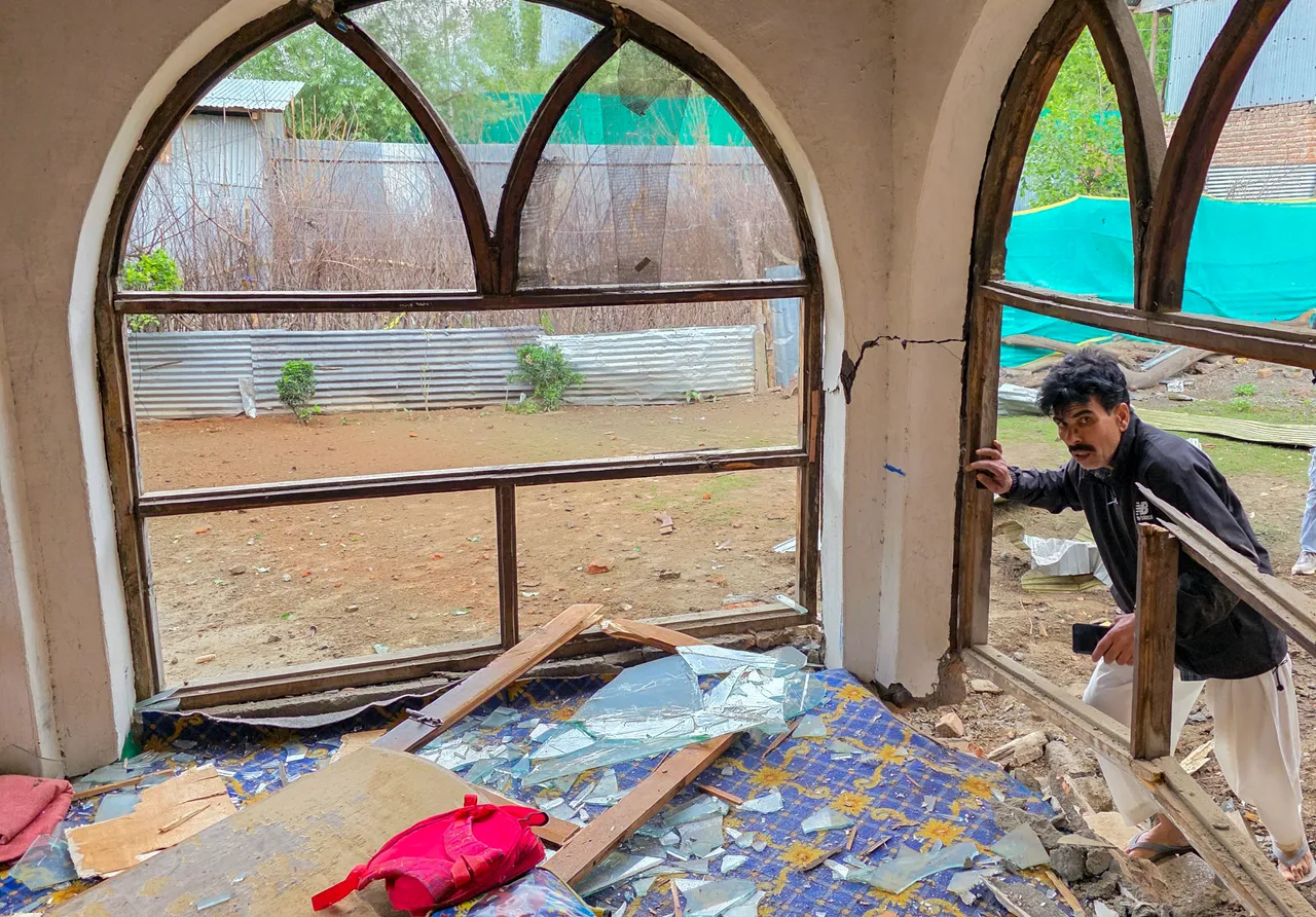  A man looks at his house damaged after shelling by Pakistani troops, in Gingle area of Uri in Baramulla