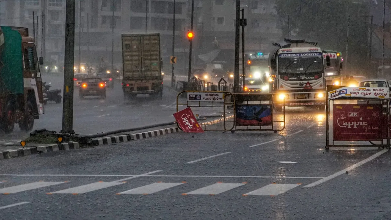 Vehicles ply on road amid heavy rainfall, in Mangaluru, Karnataka.