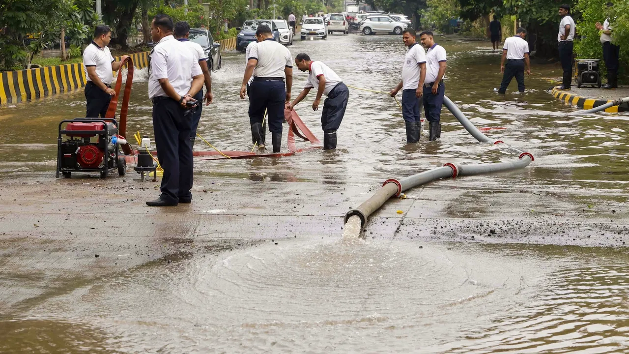 Firemen drain water from a flooded road after heavy monsoon rainfall in Navi Mumbai on Tuesday, May 27, 2025.