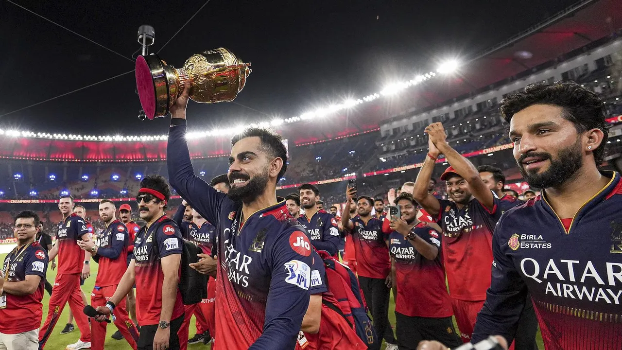 Virat Kohli holds the IPL 2025 championship trophy during the RCB team's victory lap at the Narendra Modi Stadium in Ahmedabad on Tuesday, June 3, 2025.