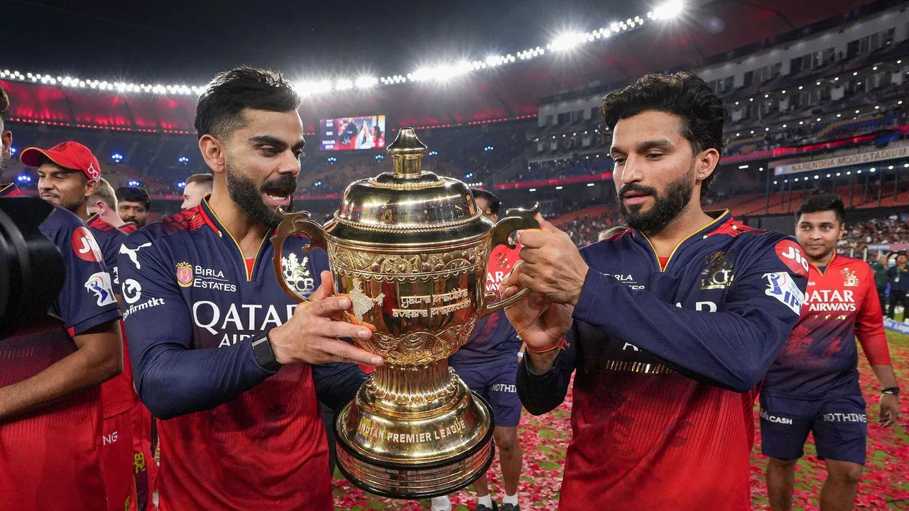 RCB captain Rajat Patidar and Virat Kohli hold the IPL 2025 championship trophy during the team's victory lap at the Narendra Modi Stadium, in Ahmedabad.