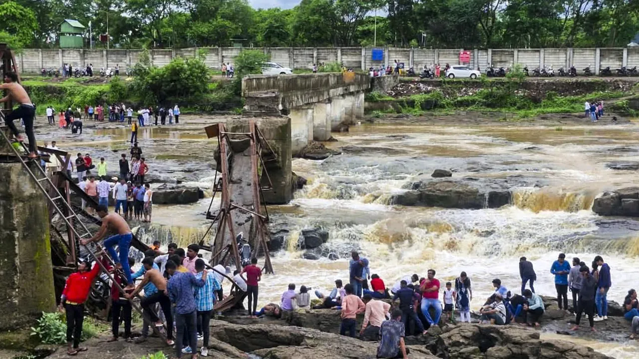 People stand near an iron bridge over the Indrayani river after it collapsed, in Pune district, Maharashtra, Sunday, June 15, 2025.