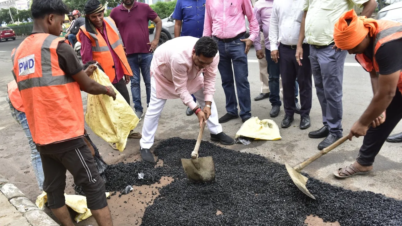 Dehi minister Kapil Mishra participates in a hands-on road repair effort on Vikas Marg, part of a PWD initiative, on Tuesday, June 24, 2025.