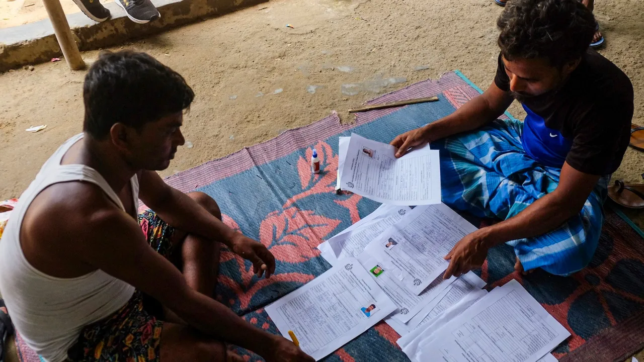 People from West Bengal fill out forms for police verification at a slum area in Gurugram on Friday, July 25, 2025.