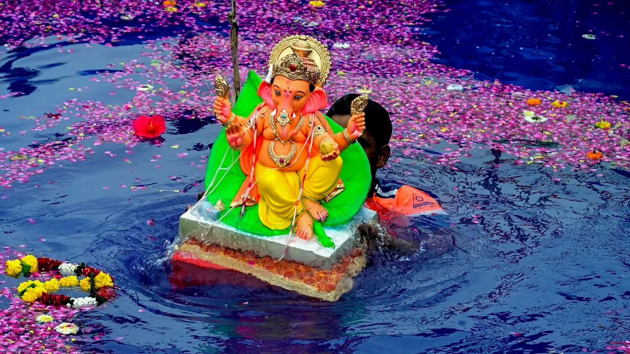 An idol of Lord Ganesh being immersed after one-and-half day during the Ganesh Chaturthi festival, at Girgaon Chowpatty in Mumbai