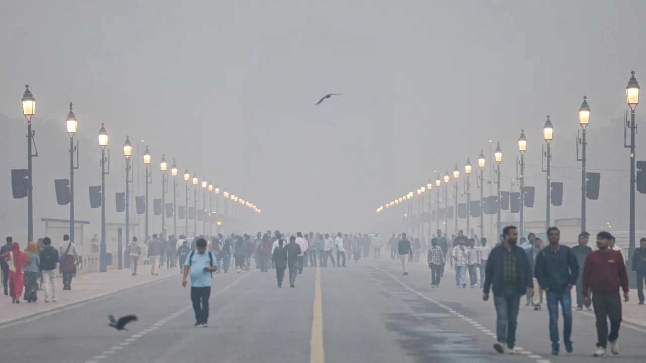 Smog engulfs Kartavya Path as people take a stroll amid low visibility, near the India Gate in New Delhi