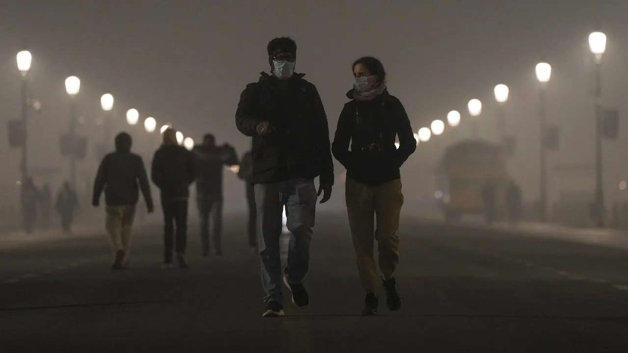 Pedestrians wear masks as a layer of smog engulfs the city amid deterioration in the capital's air quality, in New Delhi, Thursday, Dec. 18, 2025.