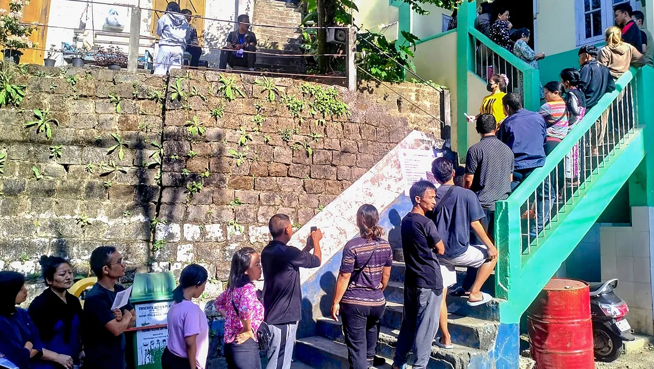 Voters wait in a queue to cast their votes for Mizoram Assembly elections, in Aizawl
