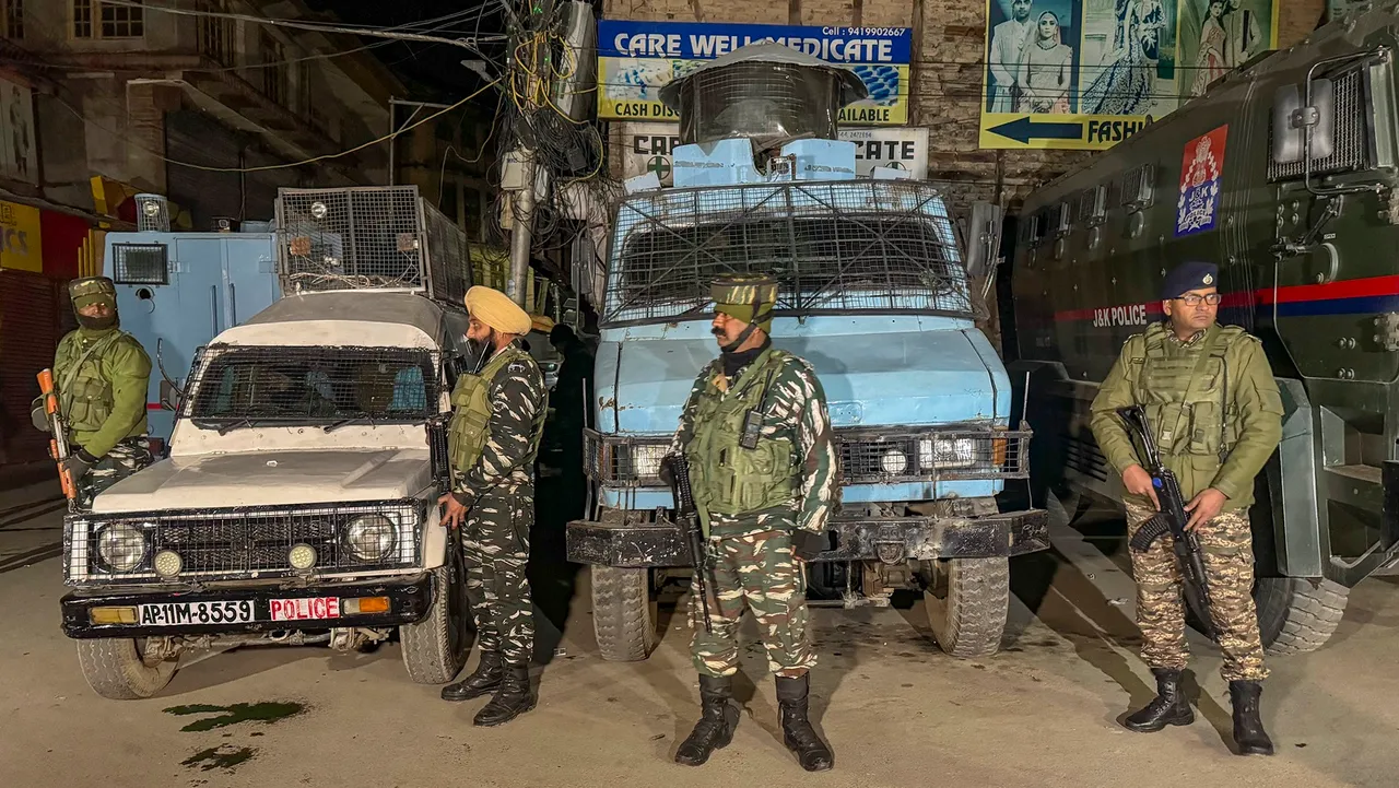 Security personnel stand guard during a cordon and search operation after terrorists shot dead a worker from Punjab