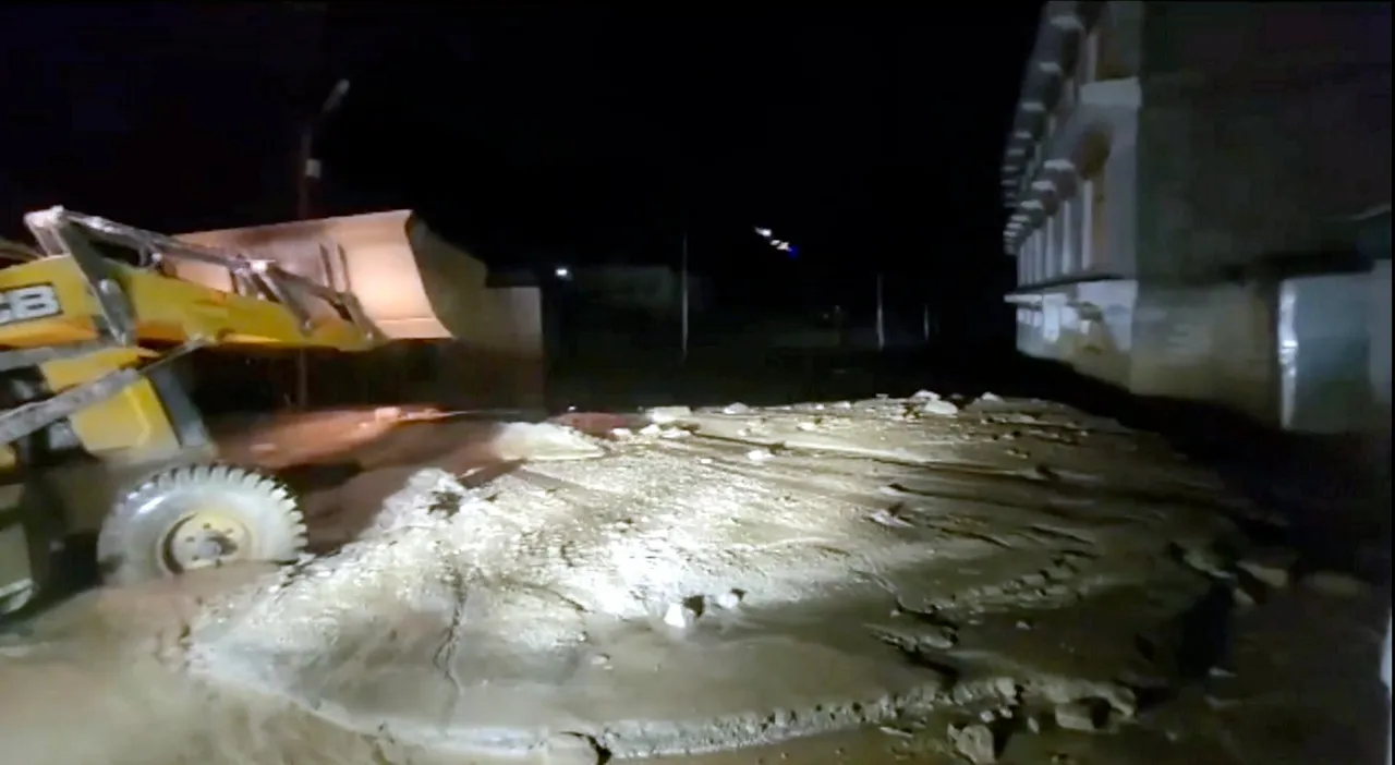 An earthmover being used to clear the mud accumulated following flash floods triggered by heavy monsoon rains, in Leh