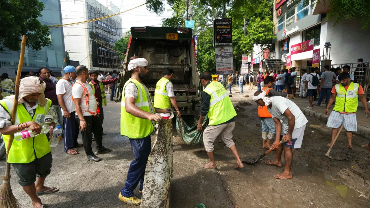 Municipal corporation workers repair a road that got damaged by rain, near a UPSC exam coaching centre, the basement of which got flooded on Saturday, resulting in the death of three civil services aspirants, in New Delhi, Sunday, July 28, 2024.