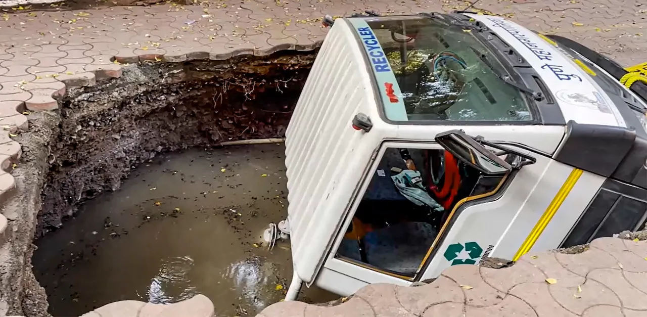 Pune Municipal Corporation (PMC) vehicle gets stuck after falling into a caved in portion of a road, in Pune, Maharashtra, Friday, Sept. 20, 2024.