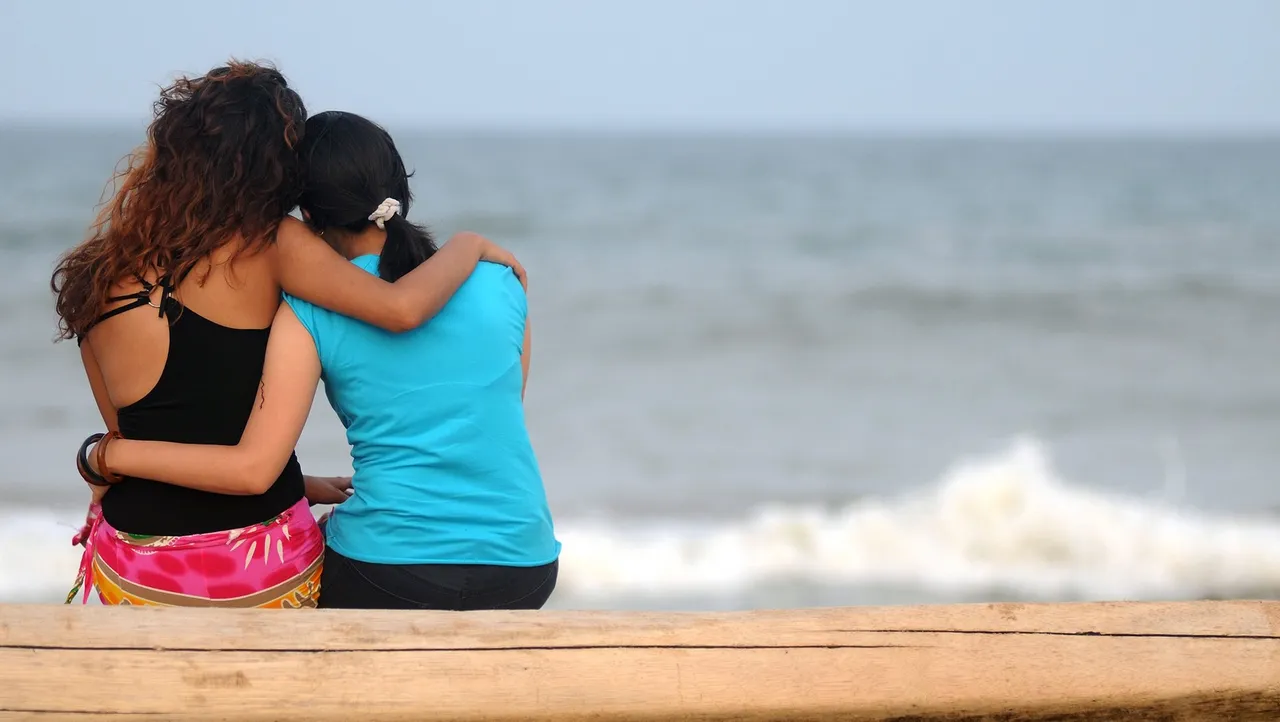 lesbian couple Two girls sitting by the beach