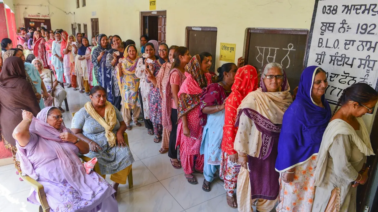 Women wait to cast their votes for the Punjab gram panchayat elections, in Jalandhar, Tuesday, Oct. 15, 2024.