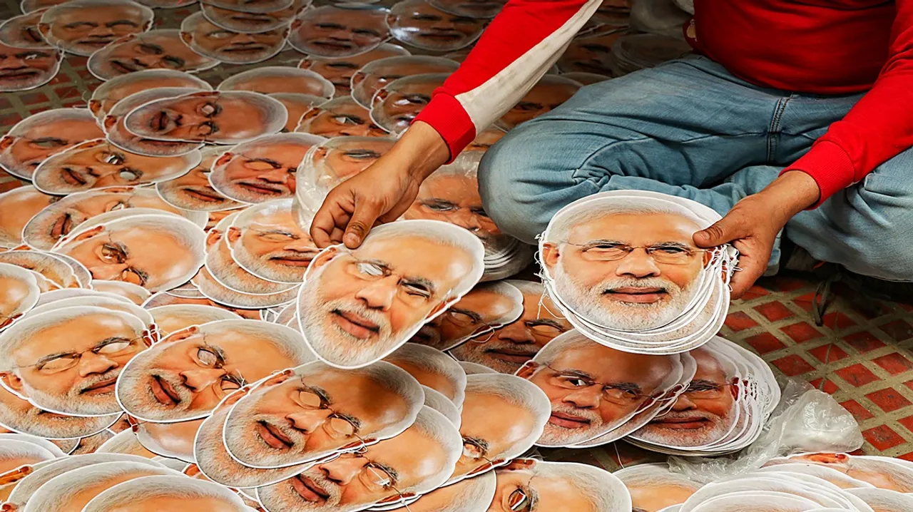 A worker arranges masks of Prime Minister Narendra Modi ahead of Lok Sabha elections, in Jammu, Tuesday, March 19, 2024