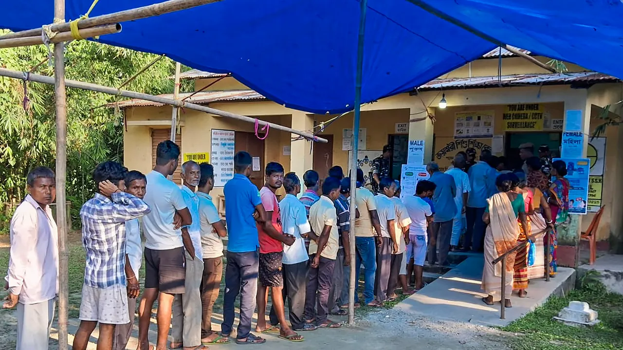 Voters wait in a queue to cast their votes during the by-elections to Dhupguri assembly seat, in West Bengal's Jalpaiguri district, Tuesday