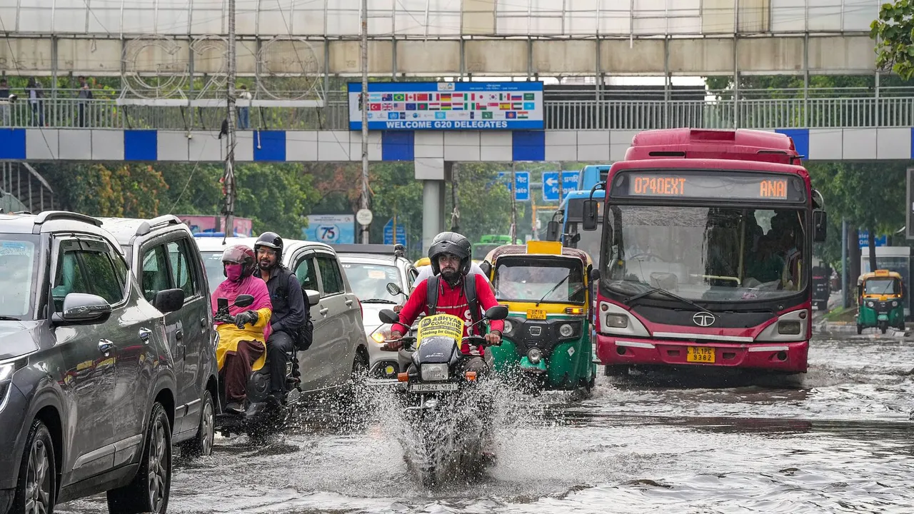Commuters wade through a waterlogged road during rains, near ITO, in New Delhi, Tuesday, July 9, 2024.