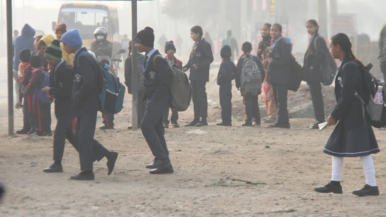 Students on their way to school dring a cold winter day, in Gurugram