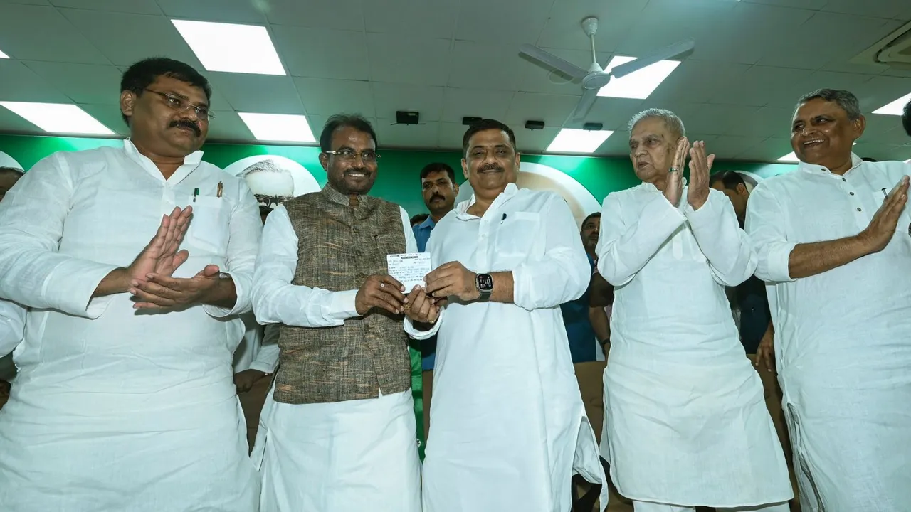 JD(U) working president Sanjay Jha presents the party membership slip to former Bihar minister Shyam Rajak as the latter joins the party, in Patna, Sunday, Sept. 1, 2024.