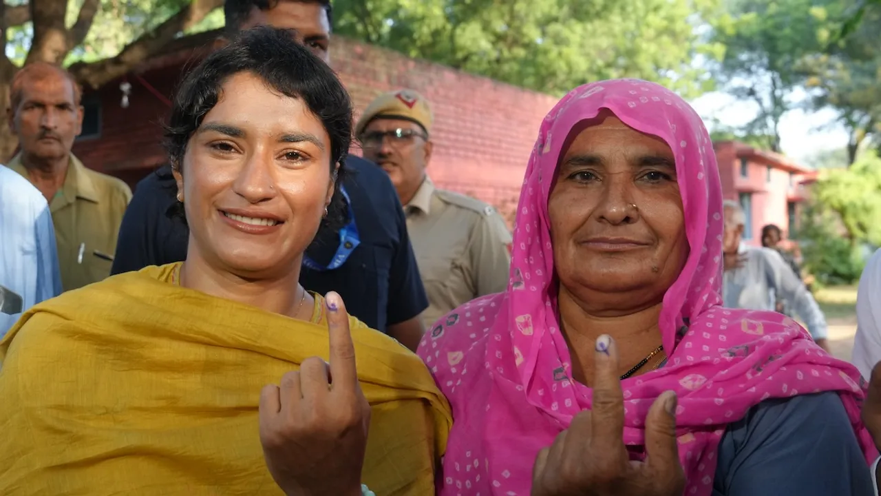 Congress candidate from Julana constituency Vinesh Phogat and her family member show their fingers marked with indelible ink after casting their votes at a polling station at Balali village during the Haryana Assembly elections, in Charkhi Dadri district, Saturday, Oct. 5, 2024.