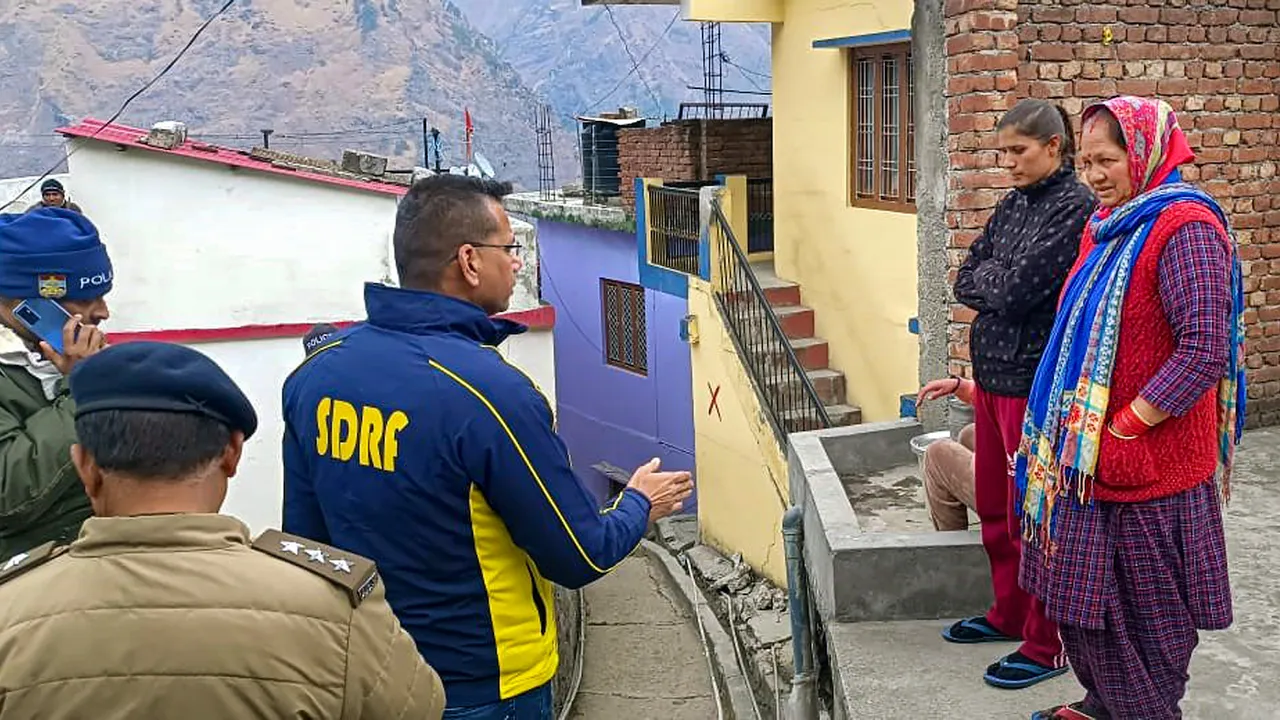 SDRF personnel interact with people after cracks appeared in their houses due to the gradual "sinking" of Joshimath in Chamoli district of Uttarakhand