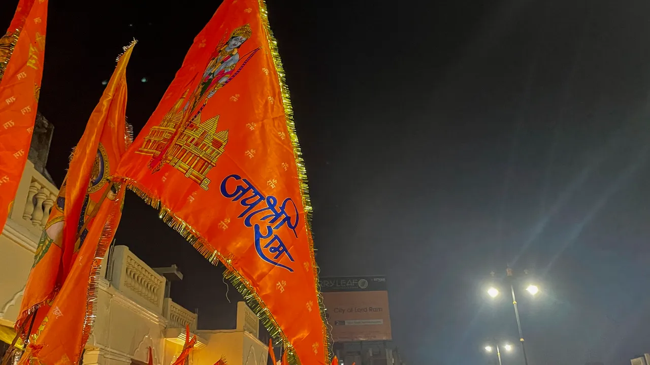 Saffron flags bearing images of Lord Ram and the upcoming grand temple on display in front of shops along Ram Path, in Ayodhya