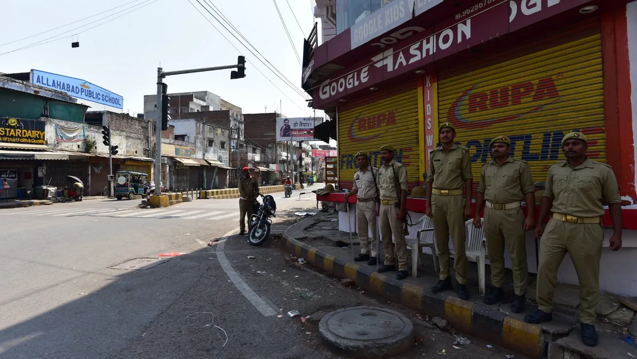 Police personnel stand guard as an area wears a deserted look following the imposition of Section 144 in Uttar Pradesh after mafioso-turned-politician Atiq Ahmed and his brother Khalid Azim aka Ashraf were shot dead by unknown assailants in Prayagraj on April 16