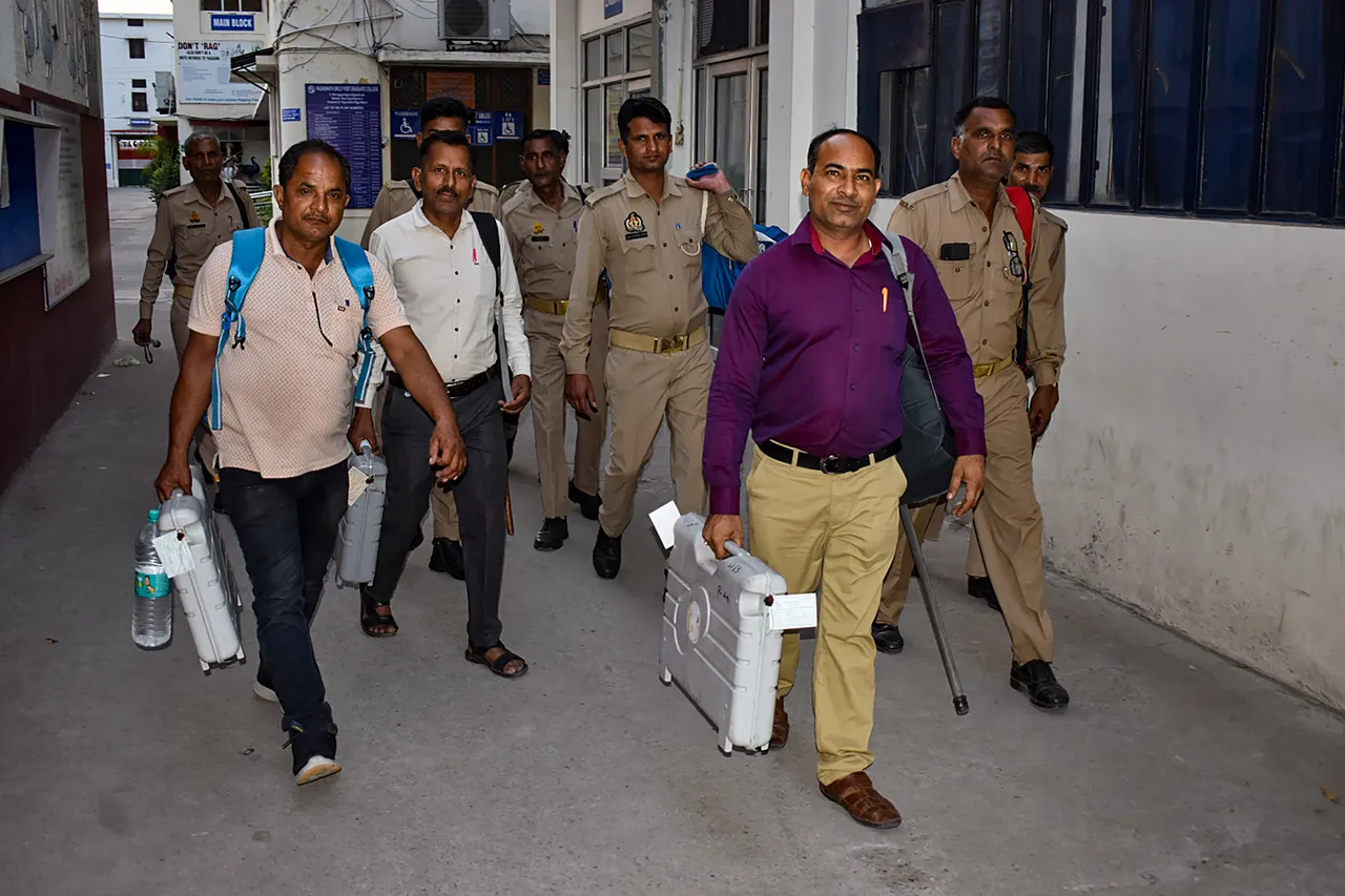 Polling officials carry EVMs and VVPATs to a strong room after the end of the Uttar Pradesh civic polls, at a polling station in Meerut