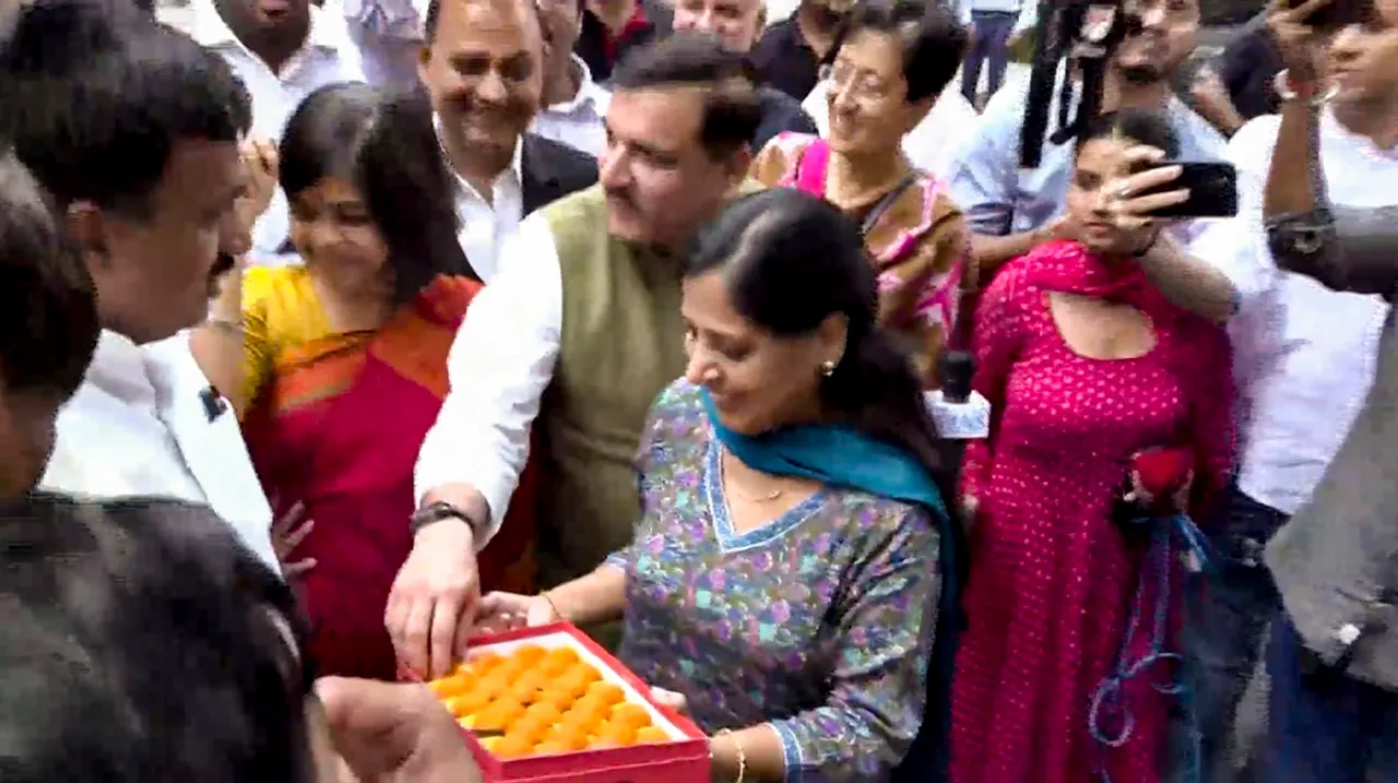 Delhi Chief Minister and AAP chief Arvind Kejriwal's wife Sunita Kejriwal offers sweets to party leaders and workers during celebrations after Kejriwal was granted bail by the Supreme Court in the now-scrapped Delhi excise policy case, in New Delhi, Friday, Sept. 13, 2024
