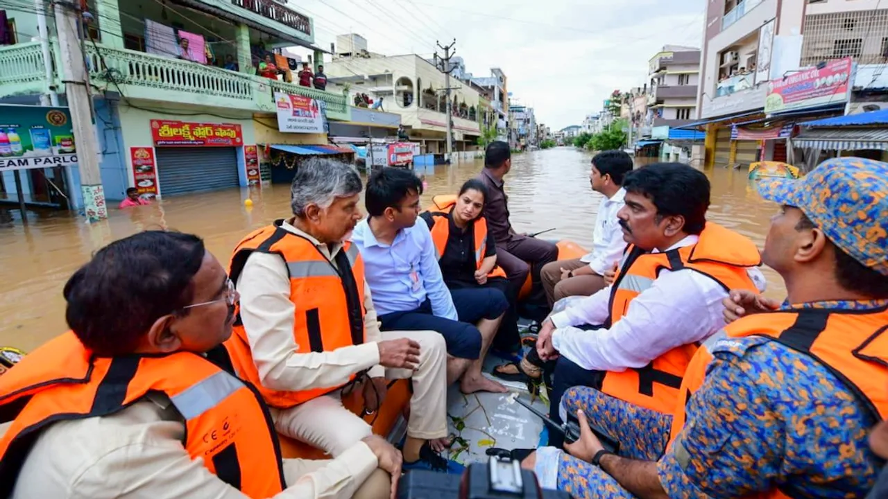 Andhra Pradesh Chief Minister N Chandrababu Naidu with others during a visit to a flood-affected area, in Vijayawada.