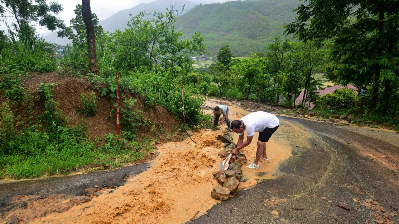 Residents divert water from a road during incessant rains, in Senapati district, Manipur, Tuesday, May 28, 2024