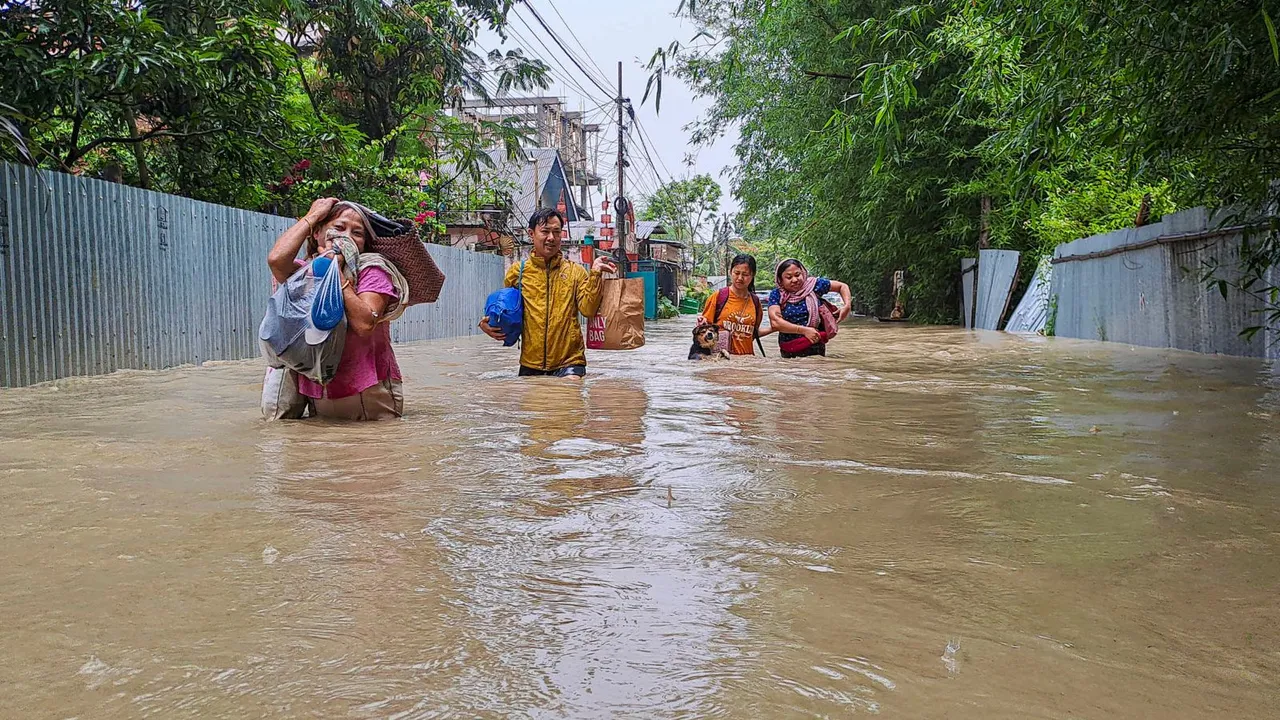 People walk through a flooded street following rains after the landfall of Cyclone 'Remal', in Imphal, Wednesday, May 29, 2024