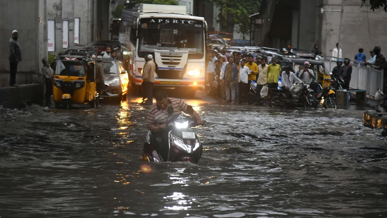A man rides a scooter on a flooded road after heavy monsoon rains, in Hyderabad, Tuesday, Aug. 20, 2024.